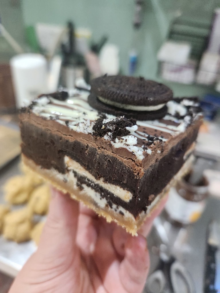 Oreo brownie topped with a whole Oreo cookie and white chocolate drizzle