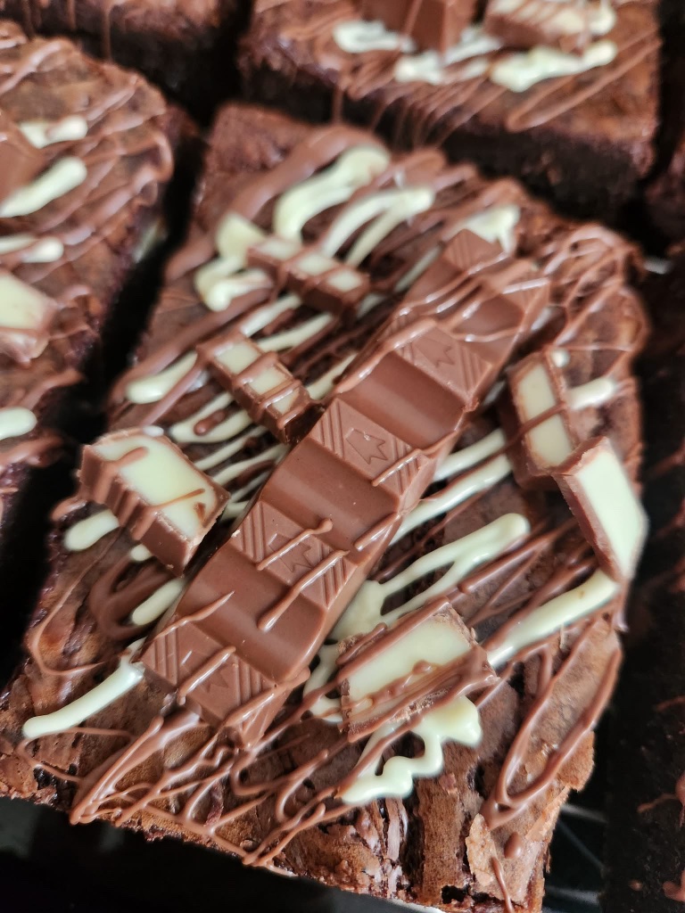 Kinder brownie topped with Kinder bar segments and white chocolate drizzle