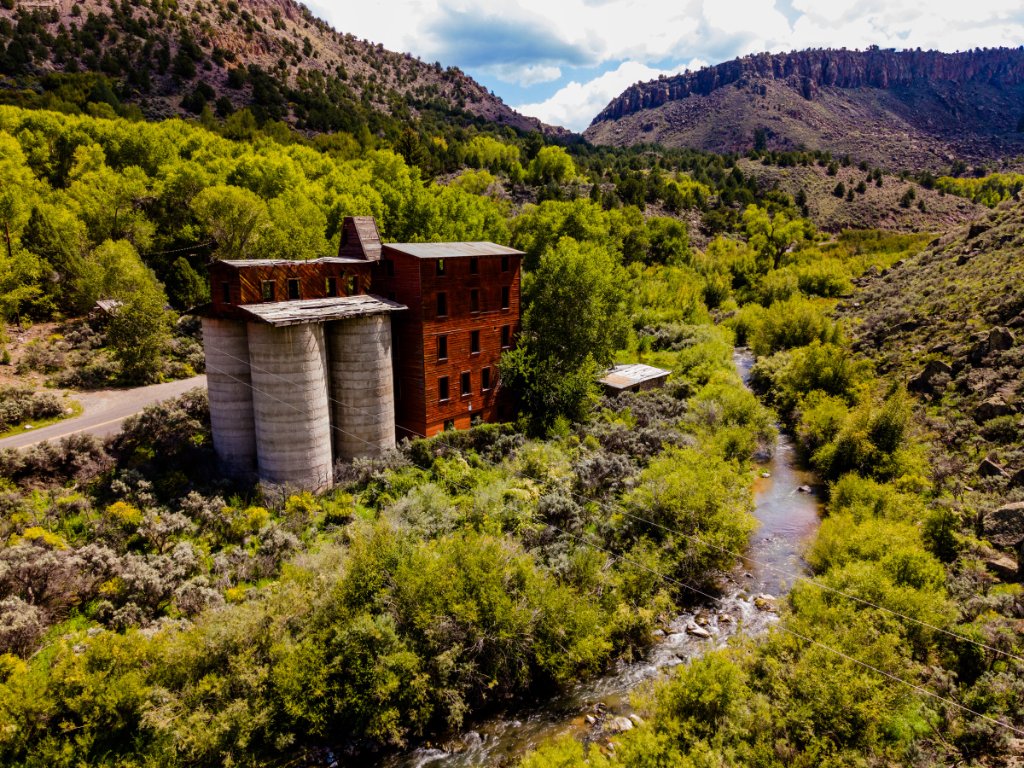 Aerial view of a historic industrial structure in a broad landscape setting.