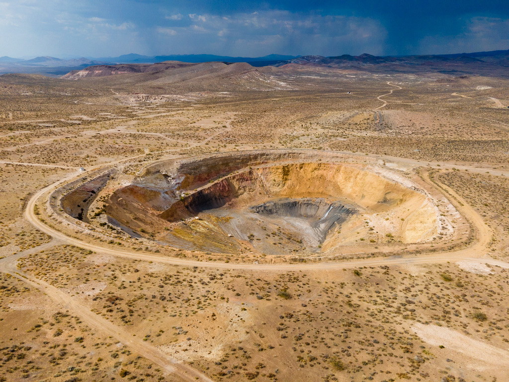 Aerial view of a remote open-pit mine in a desert industrial environment.