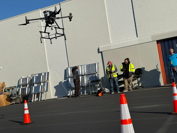 A professional drone flight taking place inside a controlled operating area marked with safety cones.