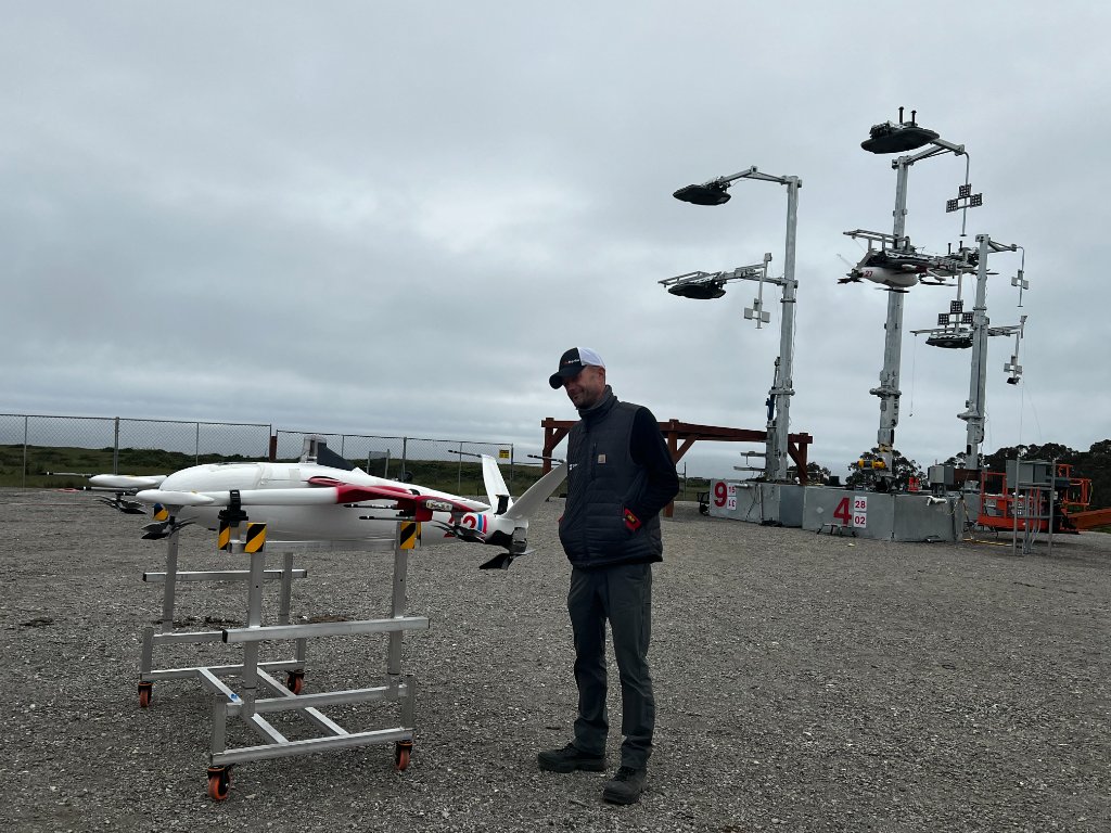 Christopher Kabat standing with a large uncrewed aircraft and launch systems during field operations.