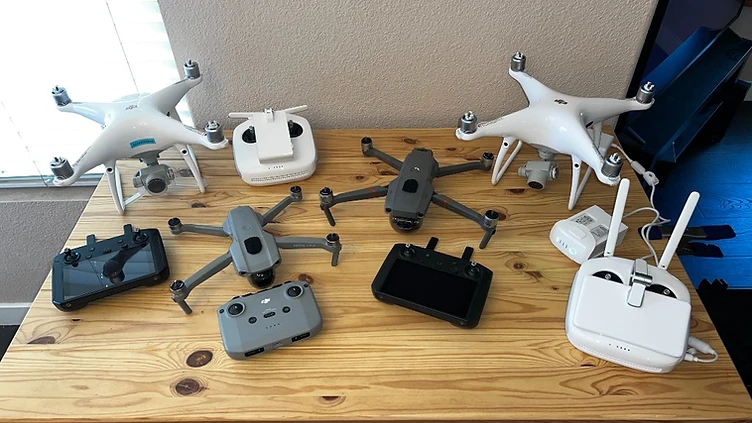 A collection of small uncrewed aircraft and controllers arranged for training and field use.