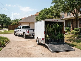 PlantCo pickup truck and trailer loaded with potted plants on a residential driveway for delivery