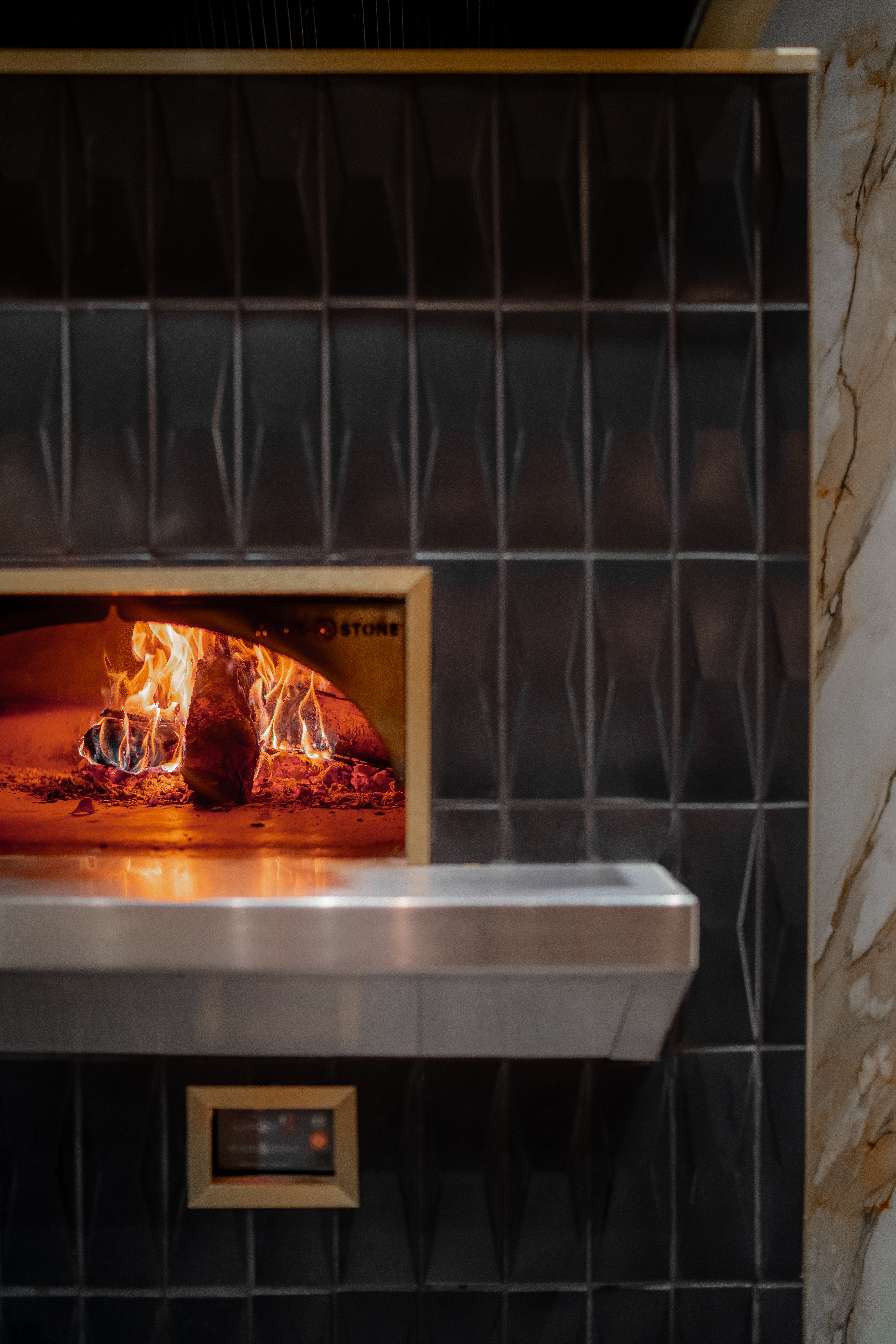 The wood-fired oven glowing inside Barley & Smoke