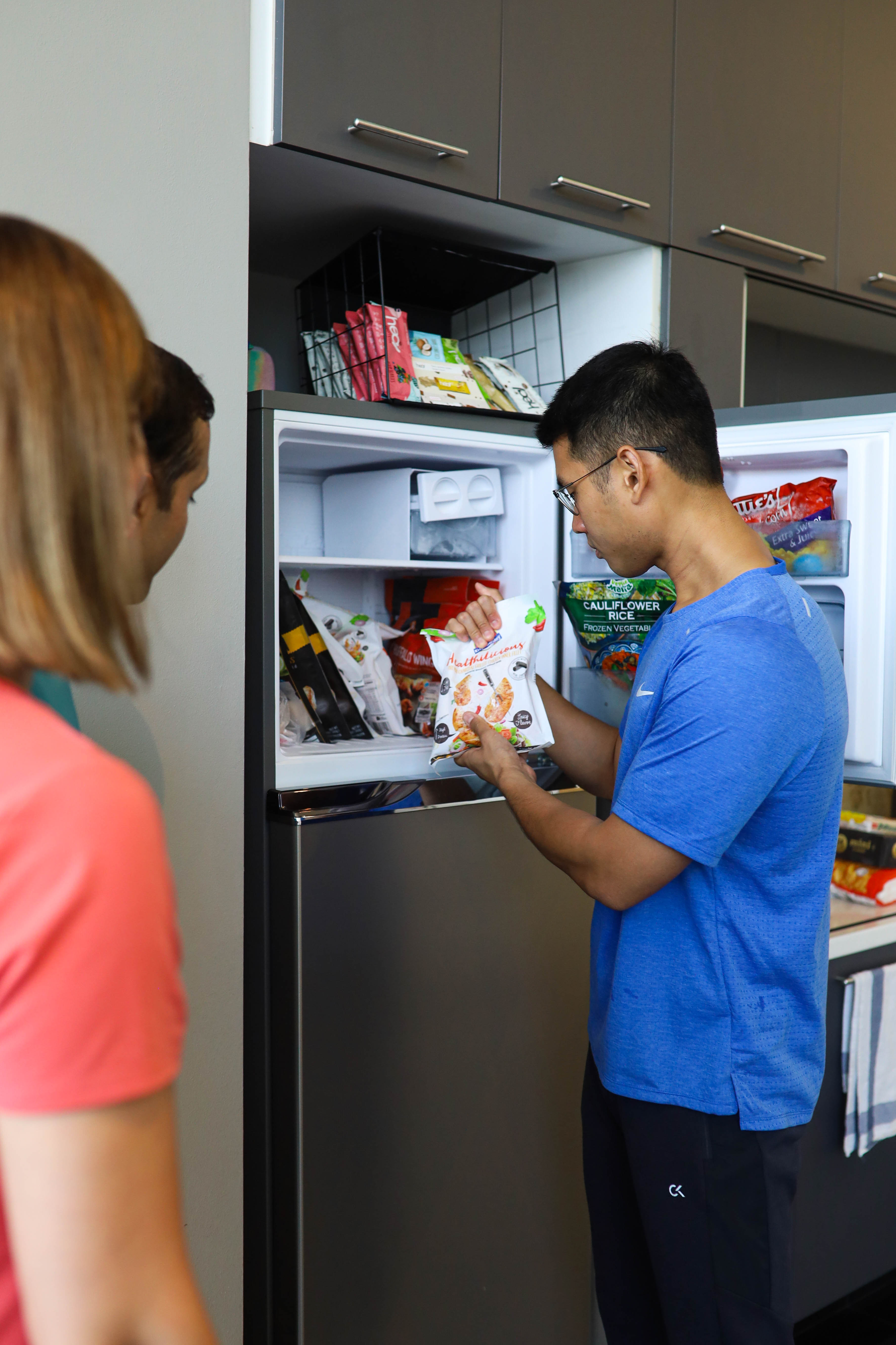 A coach showing a client frozen cauliflower rice in the kitchen