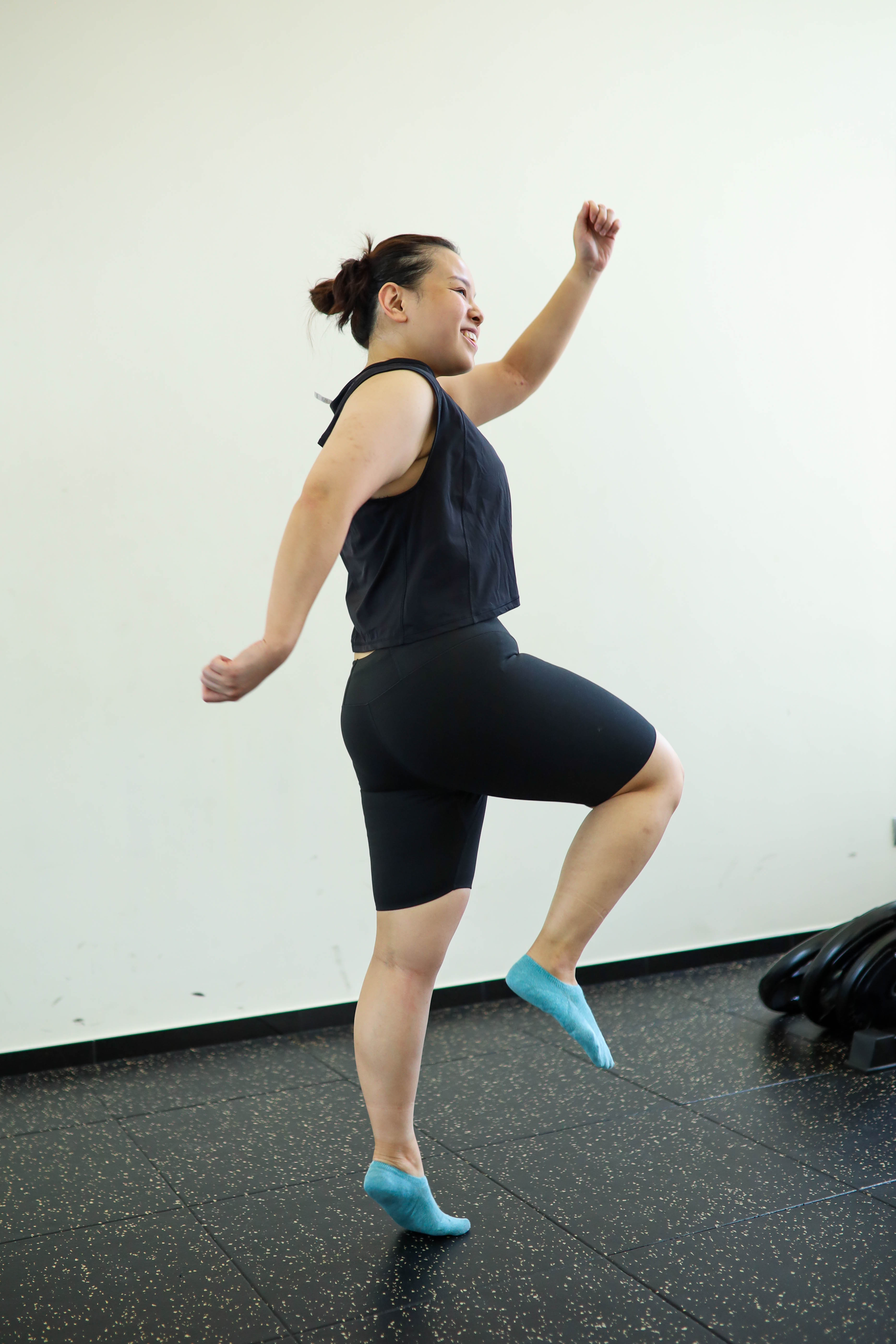 Woman performing high-knee march in the gym, illustrating Non-Exercise Activity Thermogenesis in motion