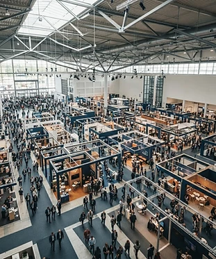 Übersicht einer großen Messehalle mit besuchten Gängen
