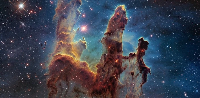 Hubble-style image of glowing pillars of interstellar gas where stars are born