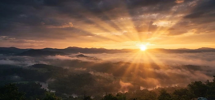 Golden sunrise breaking over a misty eastern horizon