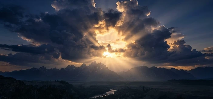 Golden sunlight breaking through towering clouds at dawn