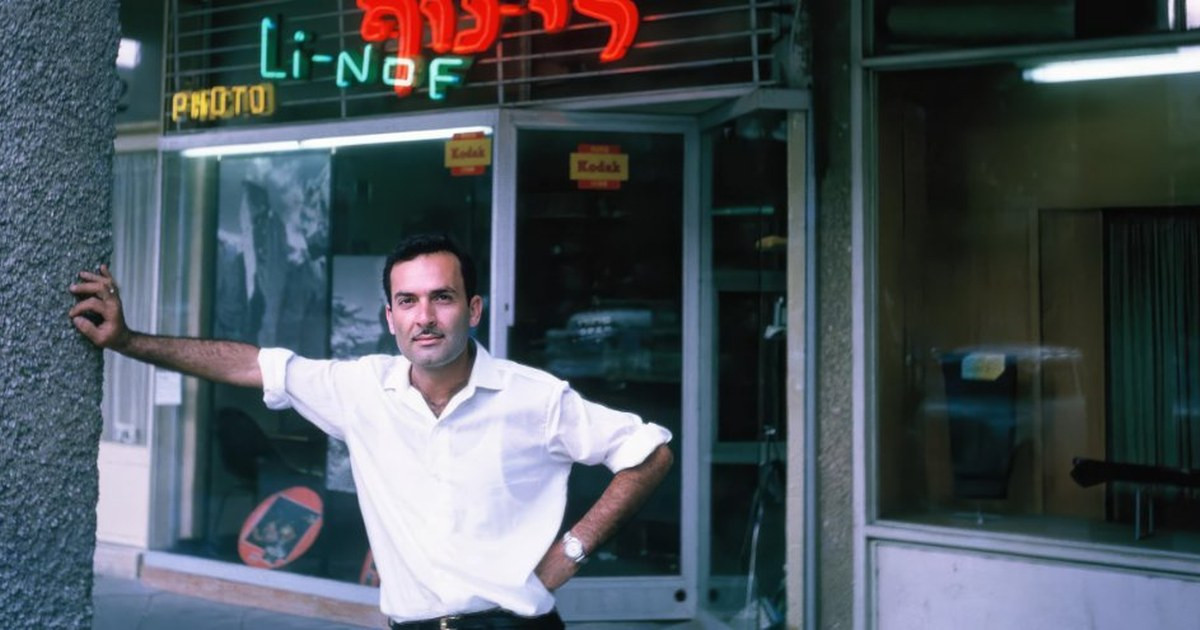 A black and white photo showing the exterior of the original Photo Linof shop from 1956, symbolizing the family legacy behind Linof.ai.