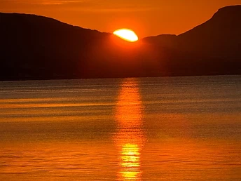 Cruise the fjords under the golden light of the Arctic midnight sun.