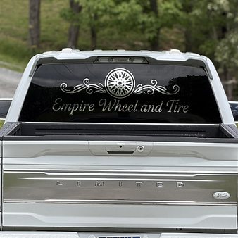 Empire Wheel and Tire silver decal applied to a white Ford truck rear window
