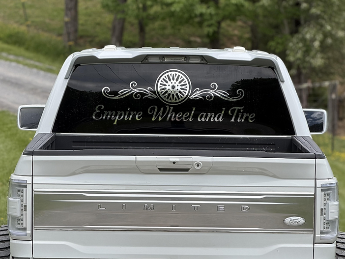 Empire Wheel and Tire silver decal applied to a white Ford truck rear window
