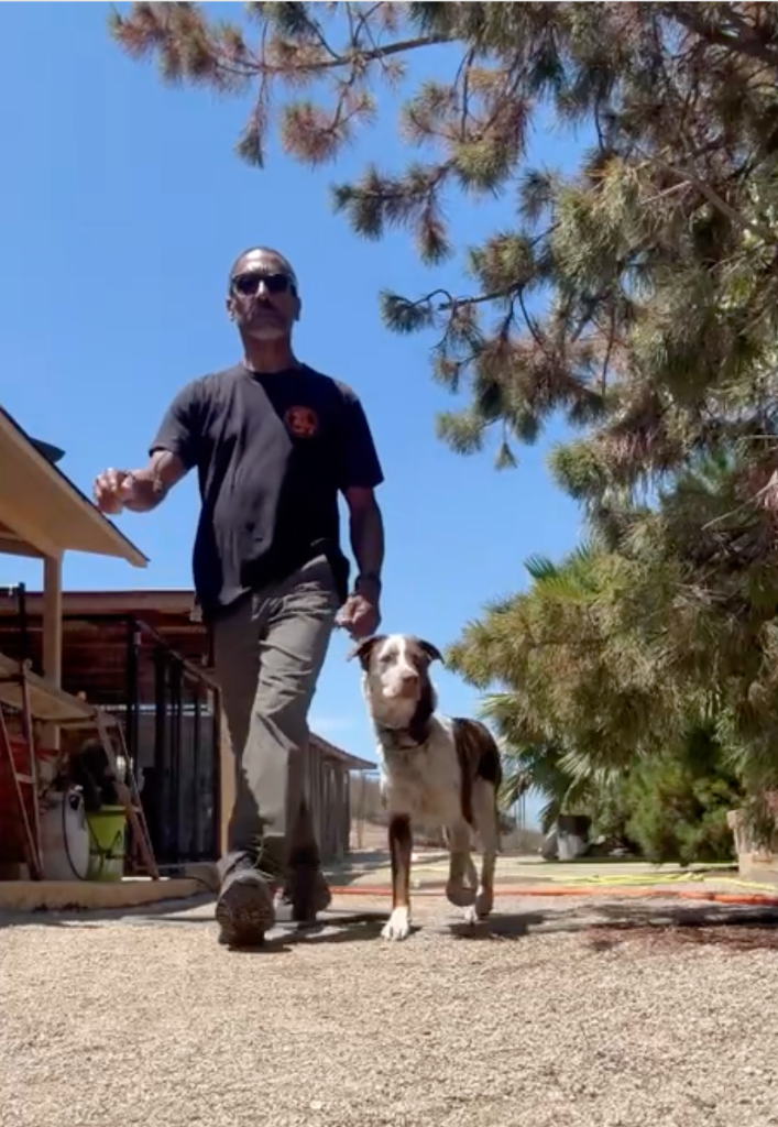 Illya with a dog at the start of a day on the property.