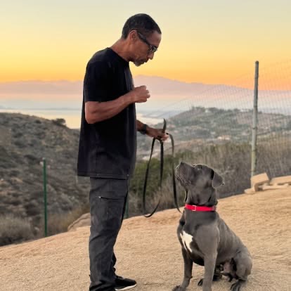 Illya Hardy training a dog on a hillside in Southern California at golden hour.