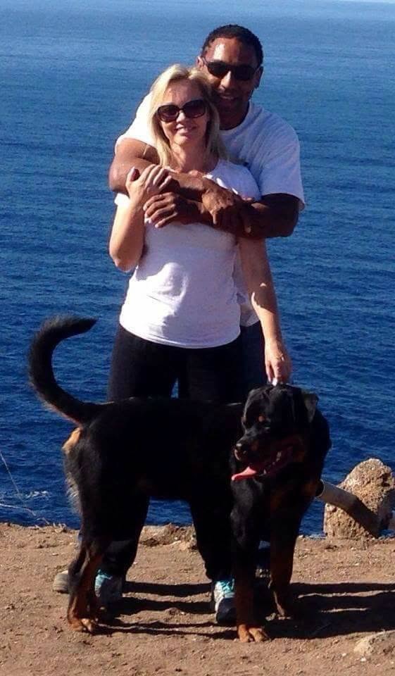 Illya and Johanna Hardy with their Rottweiler, overlooking the ocean.