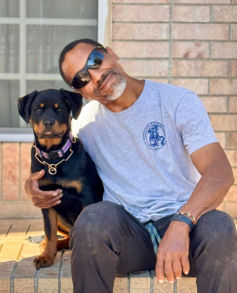 A Topline client with his Rottweiler puppy, sitting together after training.