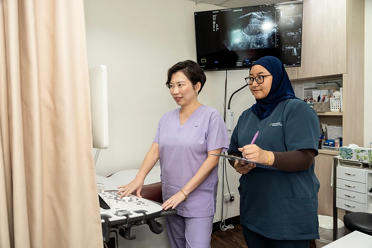 Dr Shilla Mariah performing an ultrasound scan with her clinic nurse in the treatment room