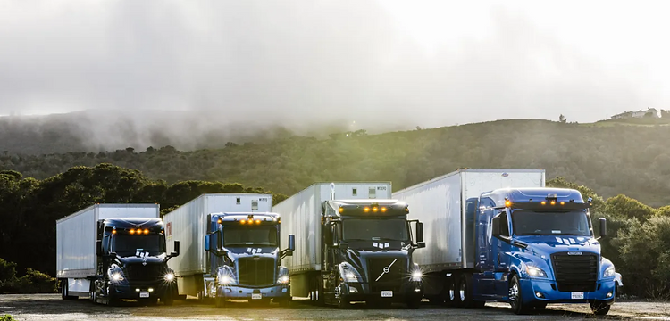 Fleet of dry van semi-trucks lined up at dusk