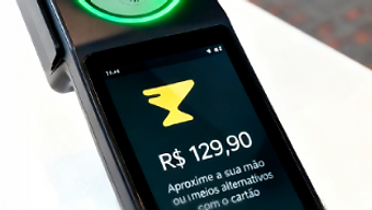Hand over a black POS terminal with a glowing green circular reader, contactless palm payment