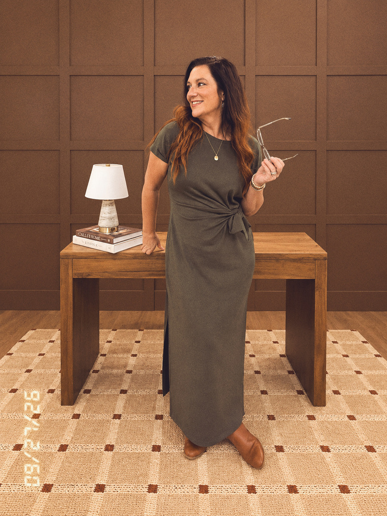 Kelly, The Mommy CEO, standing behind a wooden desk