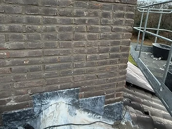 Gerendeerde bakstenen schoorsteen met vernieuwde loodslab tijdens renovatie