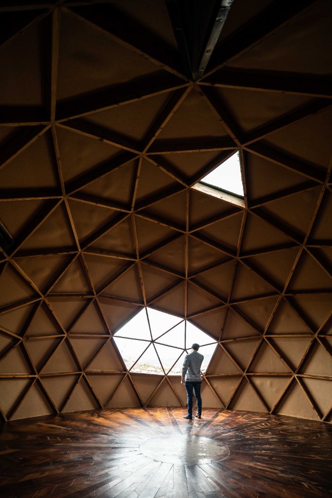 Interior de cúpula geodésica de madera con figura y luz cenital