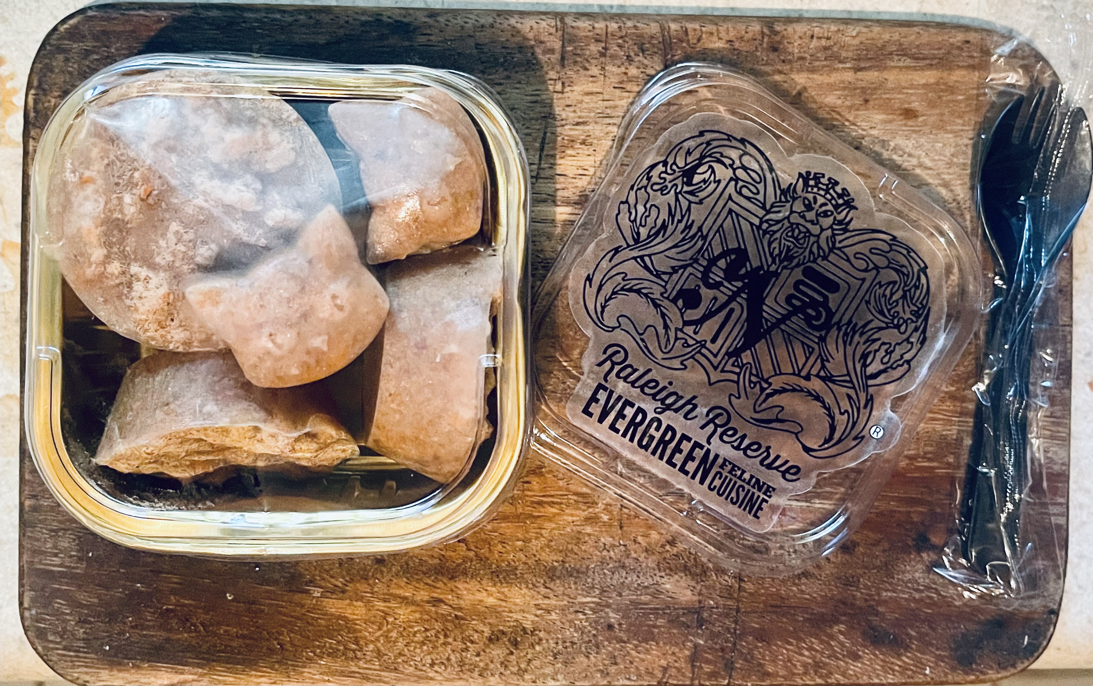 Raleigh Reserve portions and cat-head pieces beside the crest lid on a wooden board