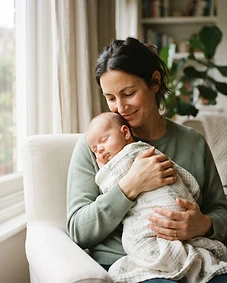 A nanny gently cradling a newborn baby