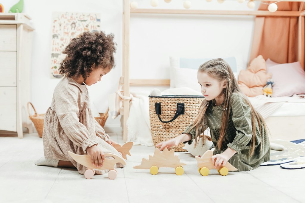 Two children playing together with wooden toys