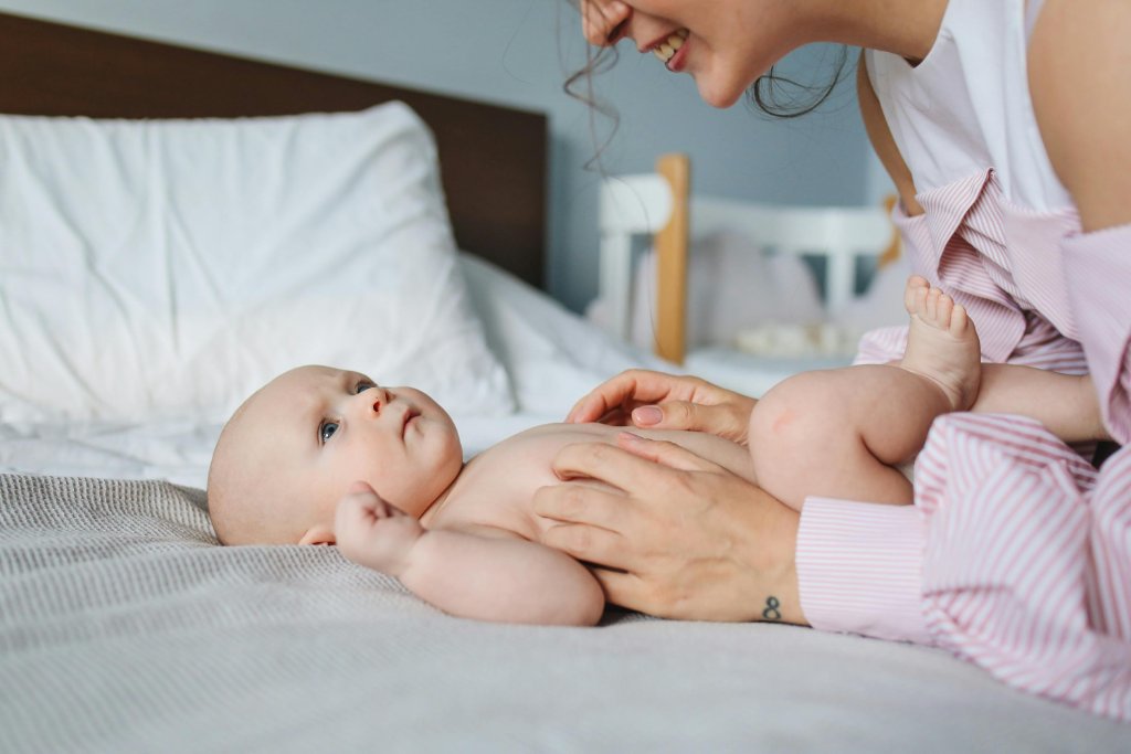 A nanny leaning in to care for a baby