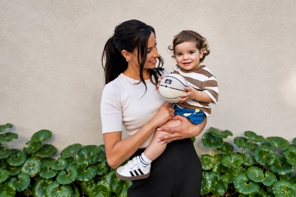 Melissa smiling down at a toddler in her arms