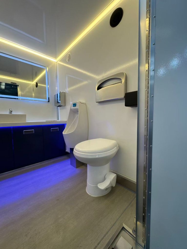 Backlit LED mirror, white vessel sink, chrome faucet, and charcoal cabinetry with under-glow lighting — a hospitality-grade finish inside.