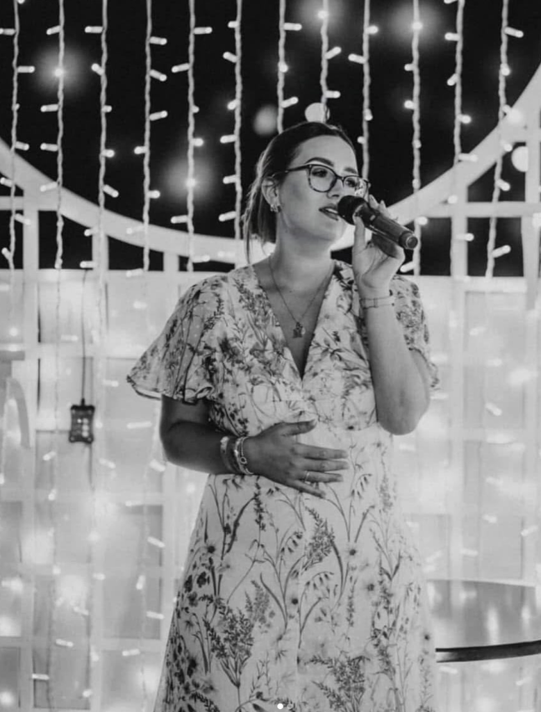 Amy Greer performing live with a microphone