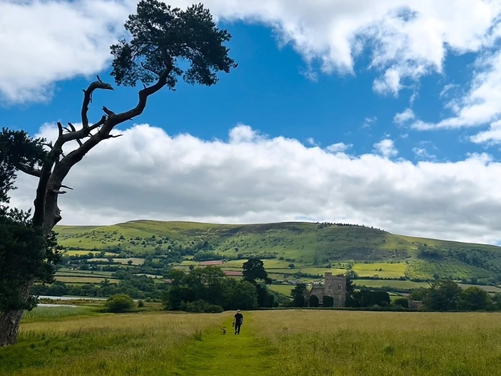 A wide Worcestershire countryside of rolling green hills beneath an open sky