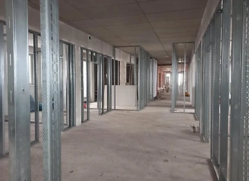 Flur im Trockenbau mit Metallständerwerk und rohem Betonboden