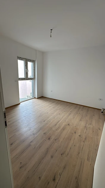 Fertig renovierter Raum mit hohem Fenster und neuem Laminatboden