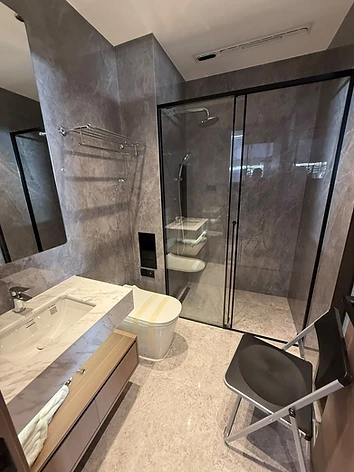 Badezimmer mit Marmorfliesen, Waschtisch mit Holzfront und Glaszugdusche