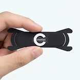 Hand holding a single Cleeneo branded nasal strip between thumb and finger