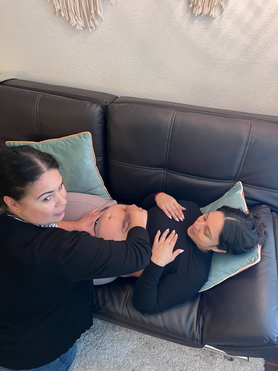 Tayna Chessman palpating a pregnant belly during a prenatal visit