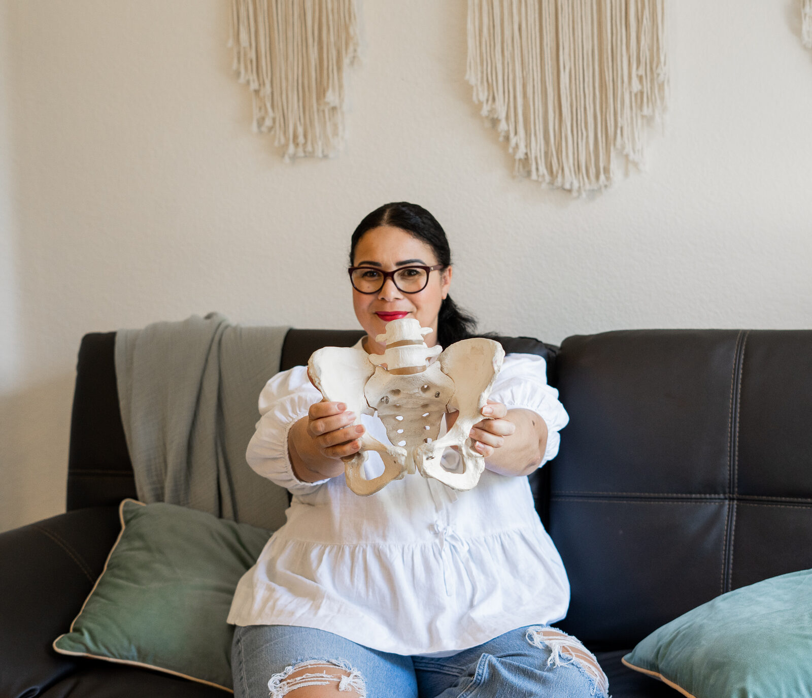 Midwife holding pelvis model to explain anatomy during consultation