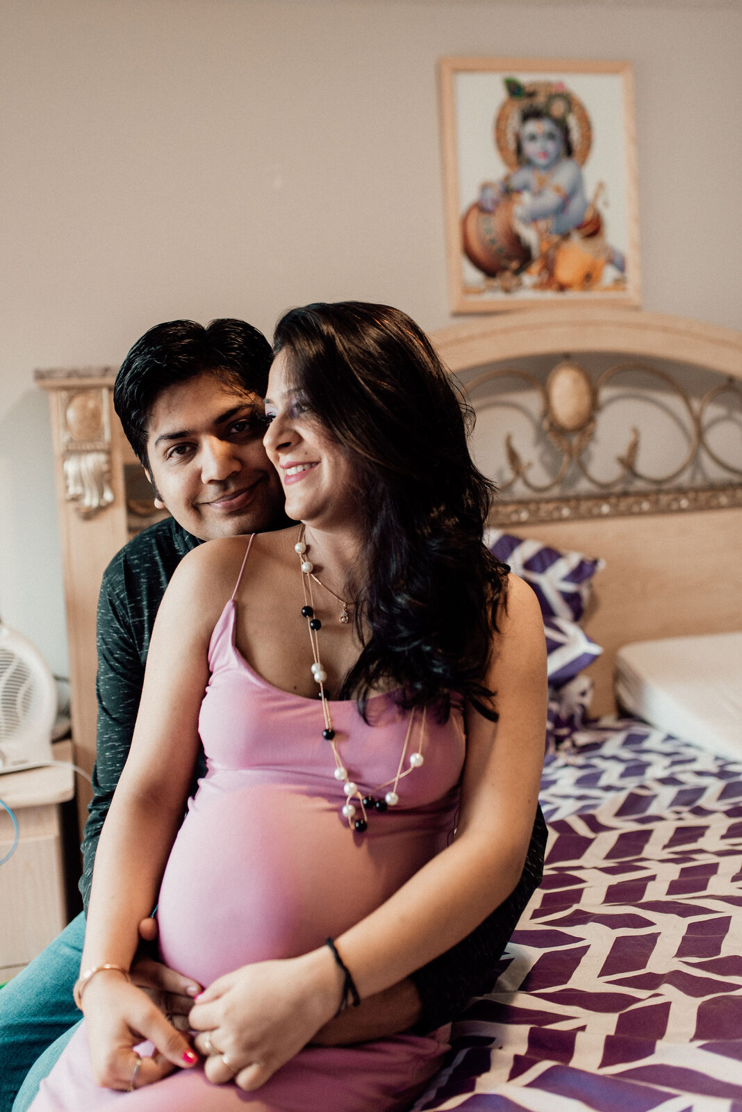 Pregnant woman and partner embracing at home in Murrieta