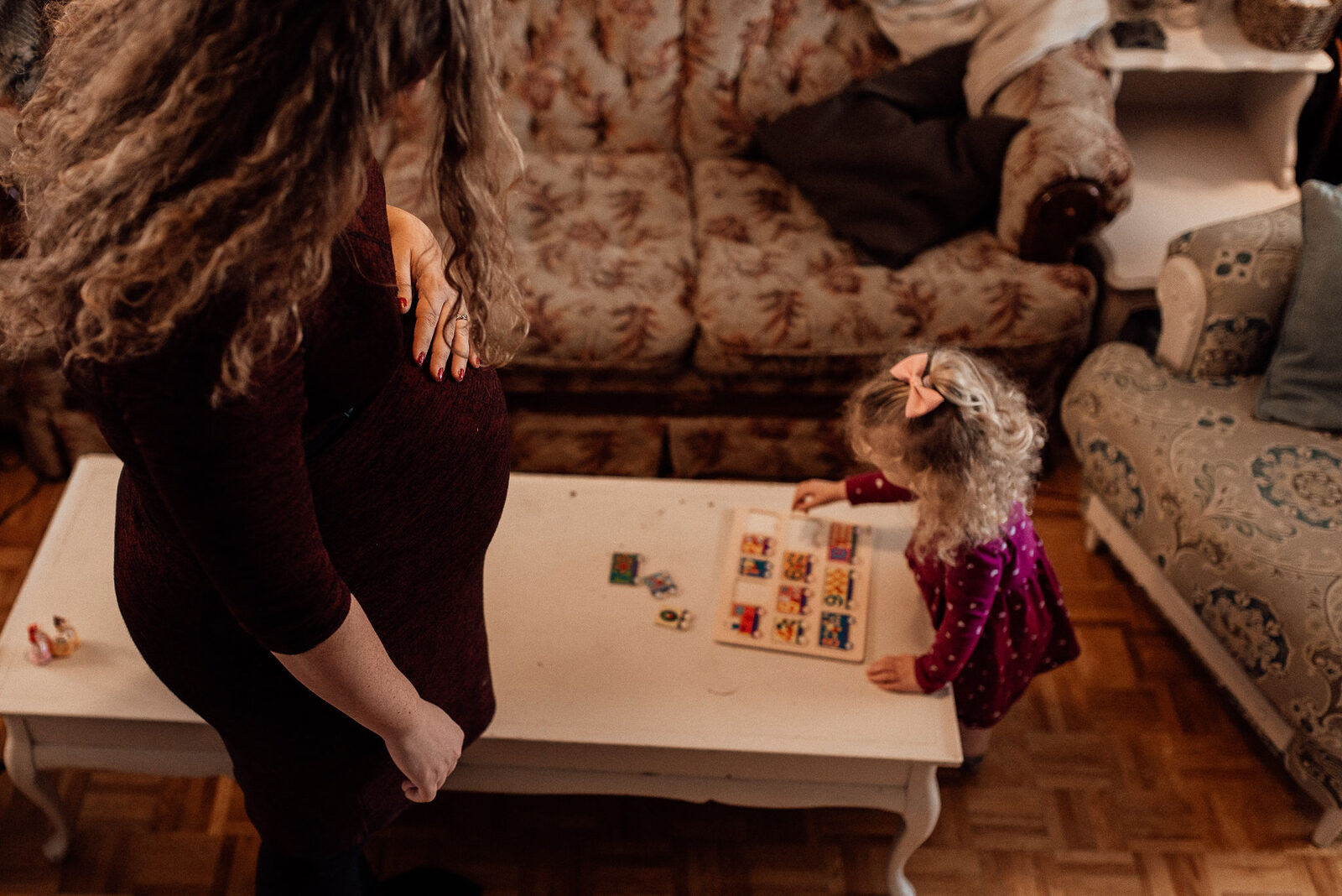 Pregnant mother with toddler daughter playing at home