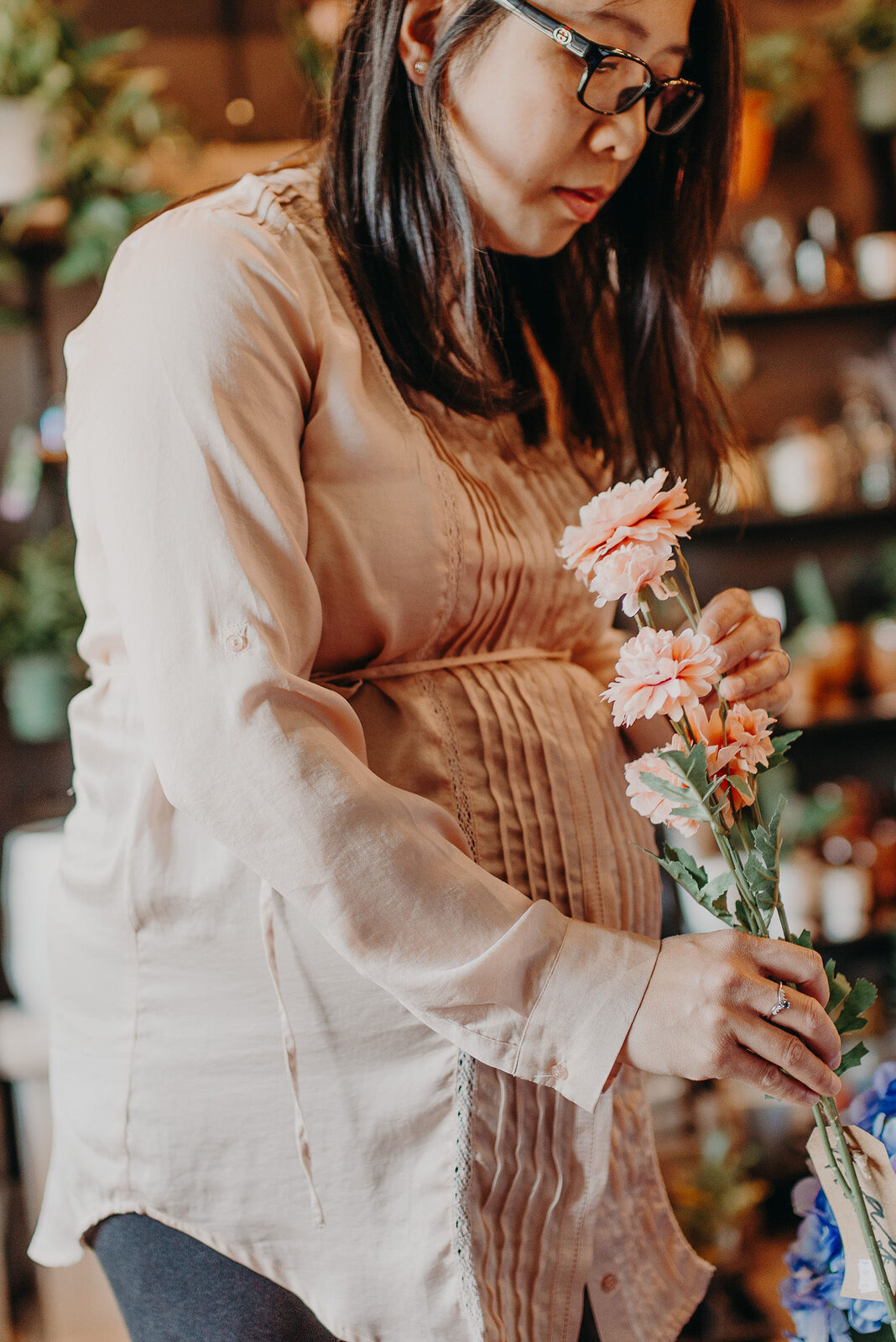 Pregnant woman thoughtfully arranging flowers