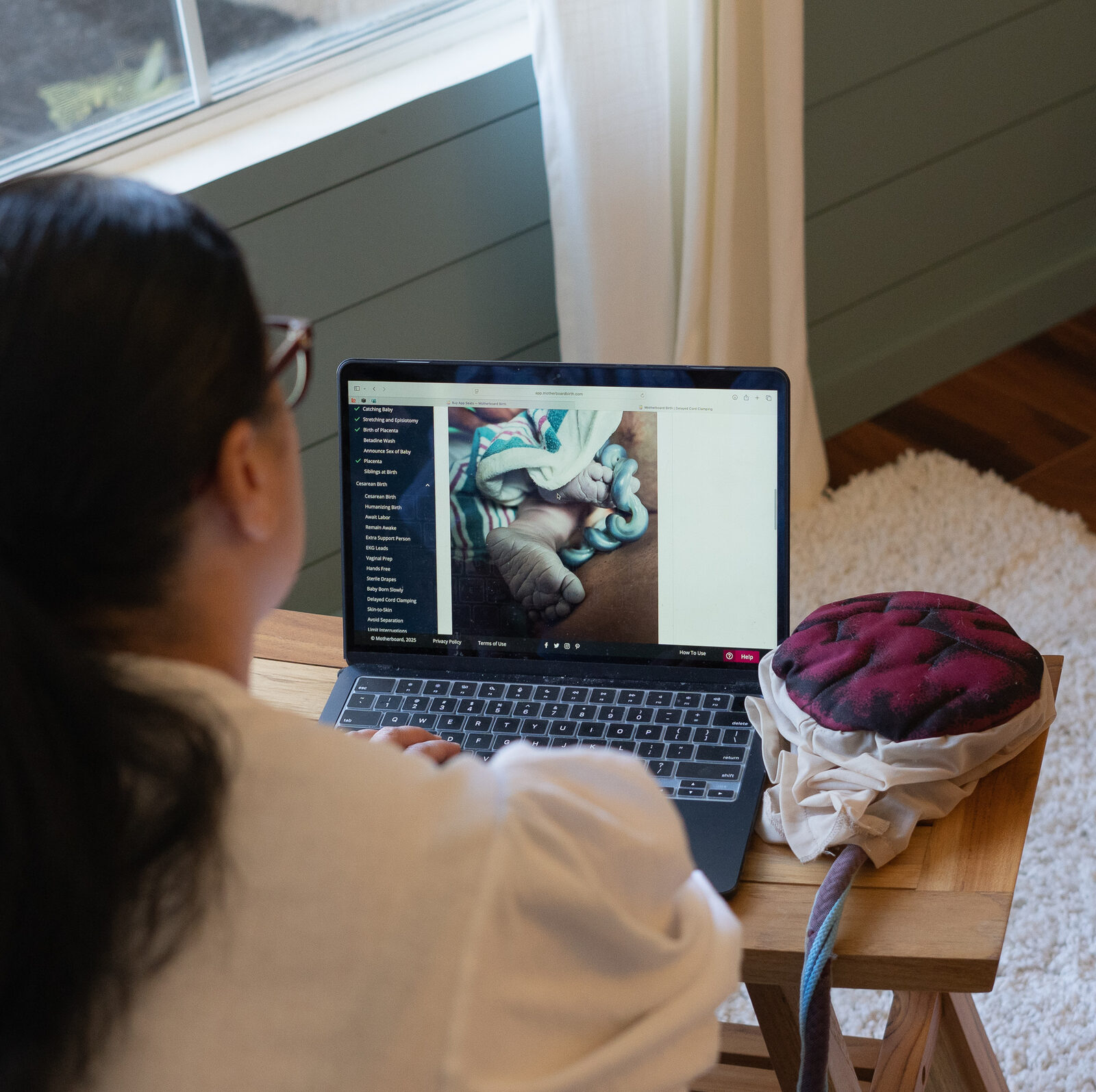 Pregnant woman researching birth plan options on laptop