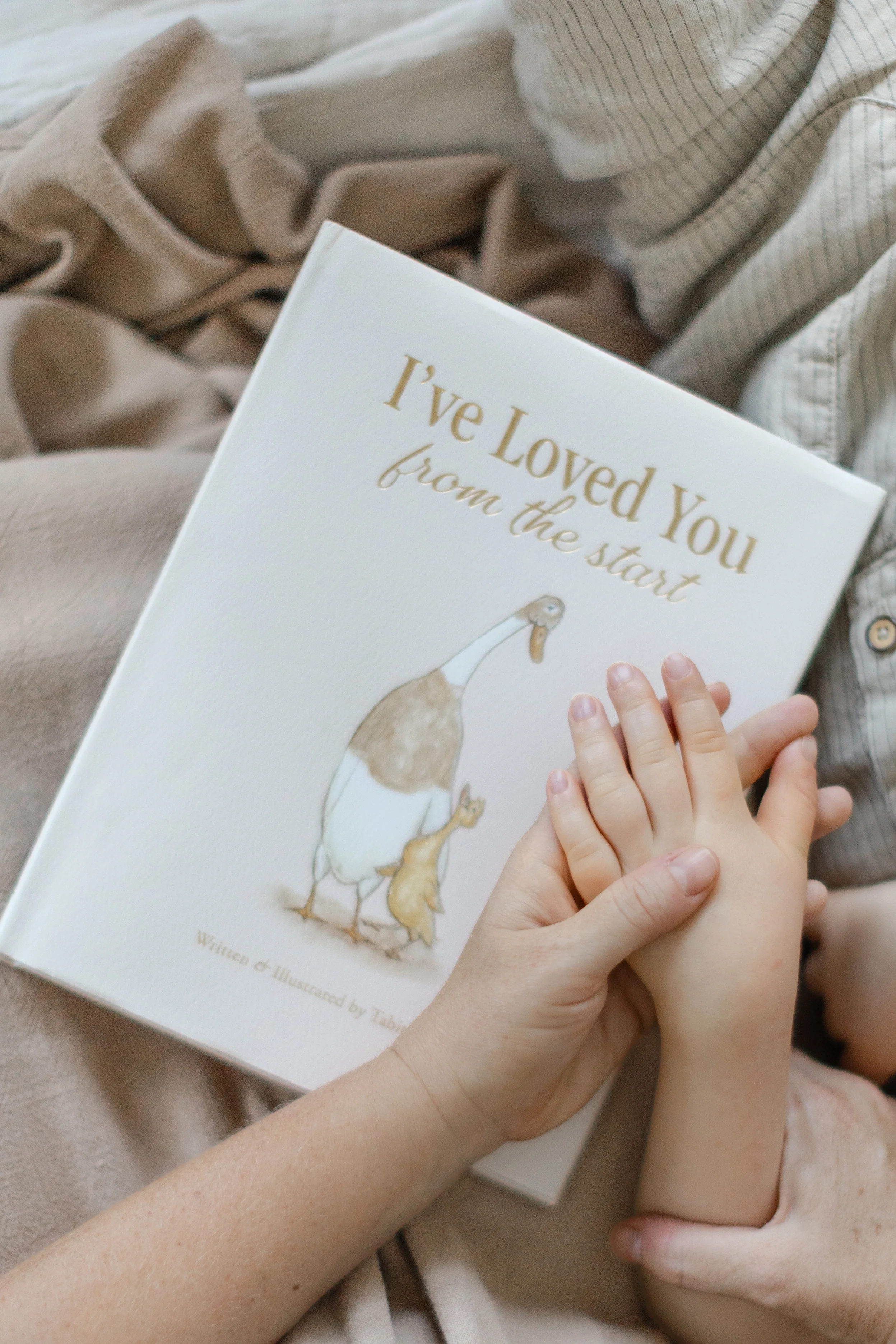 A parent and child's hands resting on the book cover