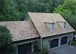 Finished roof — hand-split cedar shakes with copper valley flashing and skylight integration.