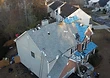 Active day on the roof — shingles being set across the rear and side slopes.